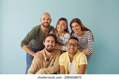 Group portrait of five happy, smiling mixed race multi ethnic friends. Team of 5 cheerful young diverse people with toothy smiles having photoshoot and looking at camera against blue studio background - Shutterstock ID 2085838870