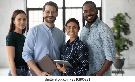 Group portrait of happy multiethnic united millennial team in modern office. Successful employees standing together, meeting in workspace, looking at camera and smiling Team work concept. Head shot - Powered by Shutterstock