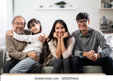 Group Portrait of Happy multigenerational asian family sit on sofa couch in living room with smile. Muti genration family happiness concept. - Powered by Shutterstock