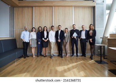 Group Portrait Of Happy Multiracial Business People. Diverse Team Of Smiling Young And Mature Entrepreneurs Or Corporate Employees Standing Together In Modern Office Interior