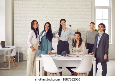 Group Portrait Of Happy Young Company Employees Gathered In Office For Corporate Meeting. Team Of Positive Successful Business Women In Their 20s And 30s Smiling And Looking At Camera All Together