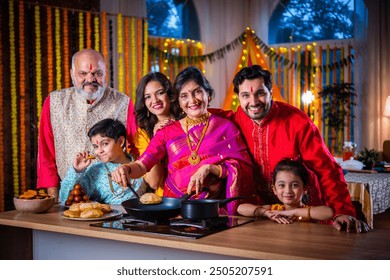 Group portrait of Indian family in traditional wear cooking food for diwali festival celebration - Powered by Shutterstock