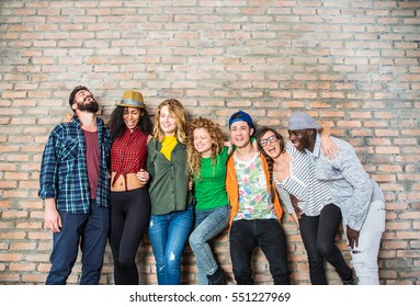 Group Portrait Of Multi-ethnic Boys And Girls With Colorful Clothes Holding Friend In Hands And Posing On A Wall - Urban Style People Having Fun, Studio Shot - Concepts About Youth  And Togetherness