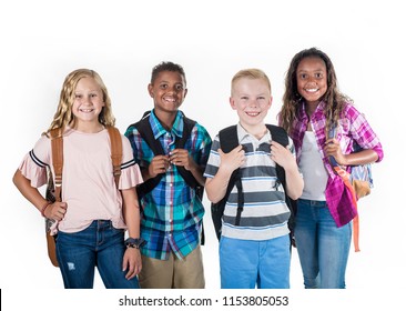 Group Portrait Of Pre-adolescent School Kids Smiling On A White Background. Back To School Photo Of A Diverse Group Of Children Wearing Backpacks Isolated On A White Background