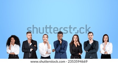 Group portrait of seven pensive diverse business people thinking standing in row over blue background. Concept of brainstorming and teamwork