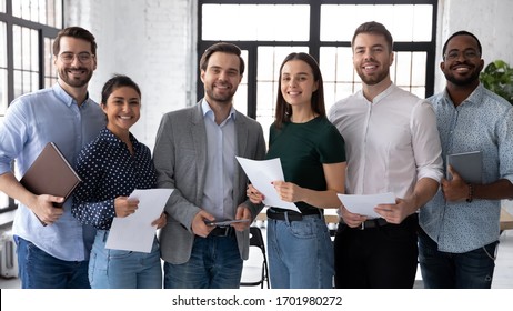 Group portrait of smiling diverse young multiethnic businesspeople posing together in modern office, happy motivated multiracial employees show unity and success, teamwork, cooperation concept