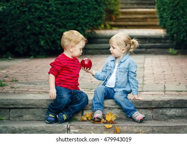 Group portrait of two white Caucasian cute adorable funny children toddlers sitting together sharing apple food, love friendship childhood concept, best friends forever - Shutterstock ID 479943019