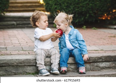 Group portrait of two white Caucasian cute adorable funny children toddlers sitting together sharing eating apple food, love friendship childhood concept, best friends forever - Shutterstock ID 617915693