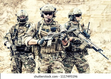 Group Portrait Of US Army Elite Members, Private Military Company Servicemen, Anti Terrorist Squad Fighters Standing Together With Guns. Brothers In Arms, War Conflict Combatants, Soldiers Of Fortune