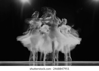 Group portrait of young, graceful ballerinas dancing on stage in black and white with motion blur effect. Movement. Concept of beauty, classic and modernity, contemporary art. Ad