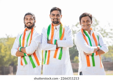 Group Portrait of young indian men wearing traditional white kurta and tricolor duppata standing cross arms at park. Election and politics, celebrating Independence day or Republic day. - Powered by Shutterstock