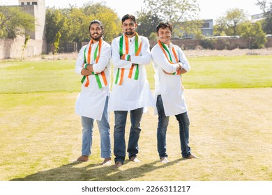 Group Portrait of young indian men wearing traditional white kurta and tricolor duppata standing cross arms at park. Election and politics, celebrating Independence day or Republic day. Full length. - Powered by Shutterstock