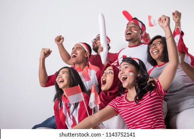 group portrait of young indonesian supporter people watching soccer match with excitement - Shutterstock ID 1143752141