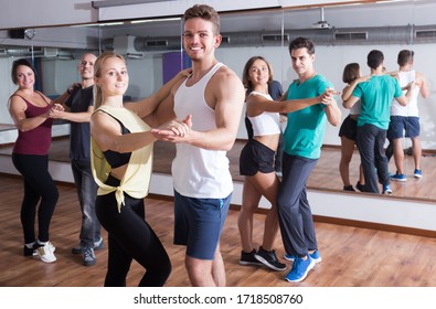 Group Of Positive Adults Dancing Salsa Together In Dance Class 