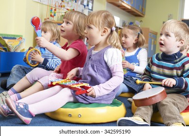 Group Of Pre School Children Taking Part In Music Lesson