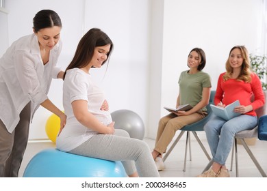 Group of pregnant women with midwife at courses for expectant mothers indoors - Powered by Shutterstock