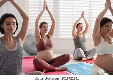 Group Of Pregnant Women Practicing Yoga In Gym