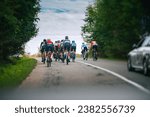 Group of professional cyclist on the road while race in summer nature. View from car in convoy. Tour on the bicycles