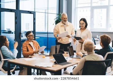 Group of professional startuppers discussing business ideas during collaborative meeting for brainstorming in office interior, successful male and female with technology talking about trade project - Powered by Shutterstock