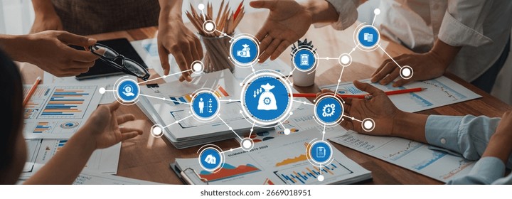 A group of professionals collaborates in an office to develop a financial reduction strategy, showcasing charts and data analysis in a modern workspace setting. Amity