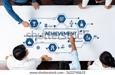 A group of professionals collaborates on a table, pointing at visuals representing achievement, success, and goals, symbolizing teamwork and strategic planning in business. Amity