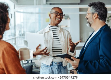 Group of professionals engaged in a lively discussion. Business woman exchanging ideas and communicating effectively with her colleagues. A vibrant and dynamic meeting in a startup office. - Powered by Shutterstock