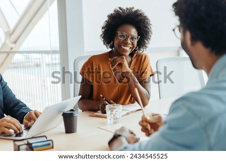 Group of professionals engages in a collaborative and creative brainstorming session in a modern boardroom. The team, led by the manager, discusses ideas and plans for a business project.