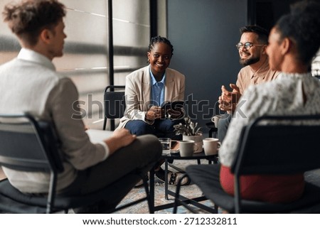 A group of professionals holding a collaborative discussion in a modern office setting, fostering teamwork and communication. Ideal for promoting business concepts like collaboration, diversity, and productivity.