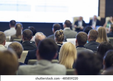 Group Of Professionals At The Round Table During The Conference. Speaking In Front Of Large Group Of People. Horizontal Image Composition