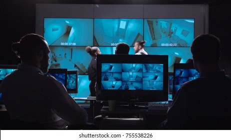 Group of professionals watching computer screen while working in office of video surveillance. - Shutterstock ID 755538226