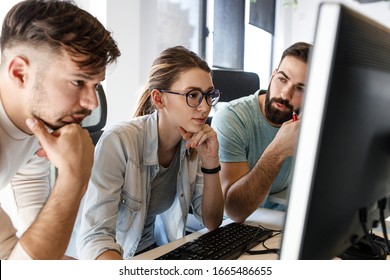 Group Of Programmers Discussing About New Project.They Looking At The Computer Screen And Testing The Code.Developing New Software.	
