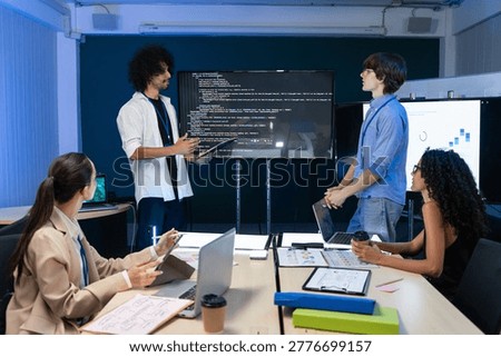 Group of programmers reviewing backend database script on screens. Professional coworkers discussing software development project during technical meeting and collaboration in office