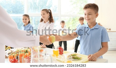Group of pupils receiving lunch in school canteen