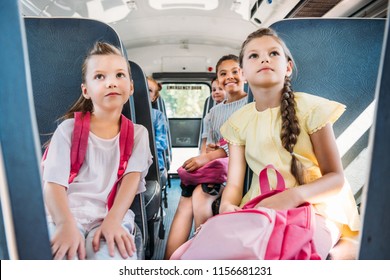 Group Of Pupils Riding On School Bus During School Excursion And Looking Up