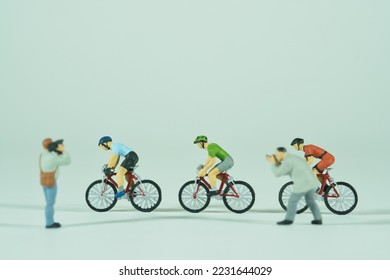 a group of racing cyclists is photographed by several photographers, light background, side view - Shutterstock ID 2231644029