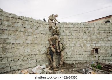 Group Of Rangers Team Climbing From A Wall