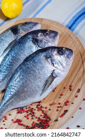 Group Of Raw Fish Prepared For Cooking On Cutting Board At Wooden Table. Healthy Seafood That Gives A Lot Of Energy At Home. Delicious Family Breakfasts, Lunches And Dinners.