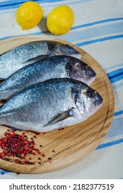 Group Of Raw Fish Prepared For Cooking On Cutting Board At Wooden Table. Healthy Seafood That Gives A Lot Of Energy At Home. Delicious Family Breakfasts, Lunches And Dinners.