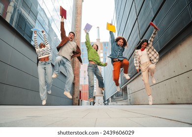 Group of real teenage students having fun jumping up at university campus. Young adult multiracial friends leaping at high school. Happy excited teens celebrating after pass the exams. Academic goal - Powered by Shutterstock