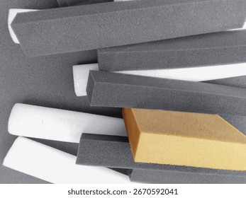 a group of rectangular foam sponges in grey, white and black colors stacked together