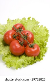 Group red tomato on leaf lettuce. Isolated over white background.