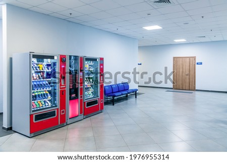 Group of red vending machines stands by the wall. Glare is reflected on a black screen. No people. Copy space for your text. Small business theme.