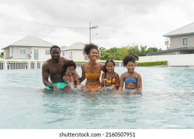 Group Of Relaxed Black African American Family, Dad, Mother And Daughter Playing By The Swimming Pool In Summer Season. People Lifestyle In Travel Holiday Vacation Concept. Relaxation.