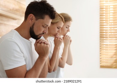 Group of religious people praying together indoors. Space for text