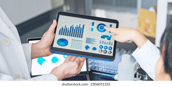 Group of researchers looking at tablet data in the lab. Research and Development. - Powered by Shutterstock