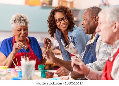 Group Of Retired Seniors Attending Art Class In Community Centre With Teacher