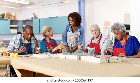 Group Of Retired Seniors Attending Art Class In Community Centre With Teacher