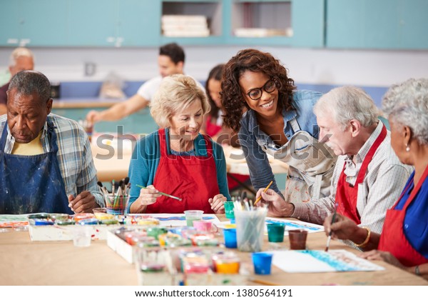 Group Of Retired Seniors Attending Art Class In\
Community Centre With\
Teacher