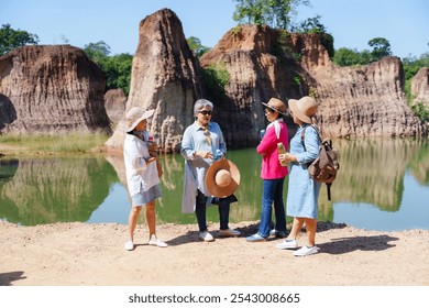 Group of retired women standing by a scenic lake, engaging in friendly conversation in a relaxed. Capturing the essence of long-lasting friendship and peaceful nature exploration in retirement. - Powered by Shutterstock