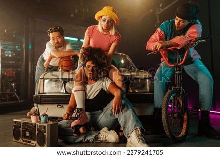 A group of retro trendy friends are hanging out together in the style of the 90s fashion outfit with bikes, roller skates, boombox and a basketball.
